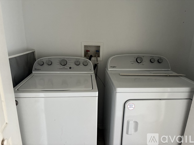 Two front loading washing machines in a small laundry room.