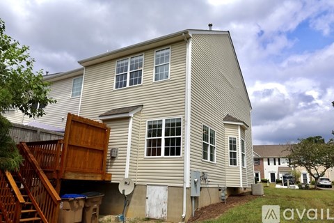 A house with a garage door open and a tree in front.