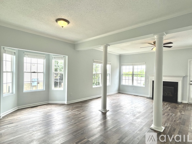 A spacious living room with hardwood floors and a fireplace.
