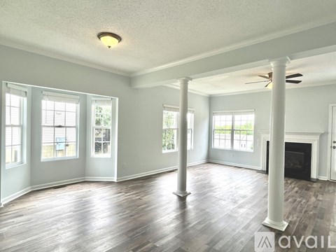 A spacious living room with hardwood floors and a fireplace.