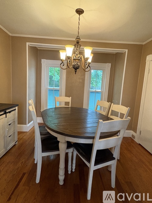 A dining room with a wooden table and chairs.