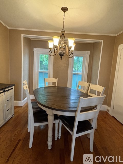 A dining room with a wooden table and chairs.
