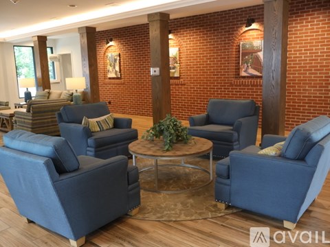 A living room with blue chairs and a glass coffee table.