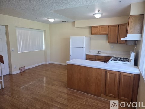 A kitchen with wooden cabinets and a white fridge.