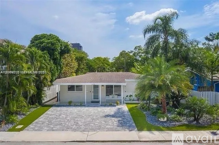 A house with a white fence and a driveway in front of it.