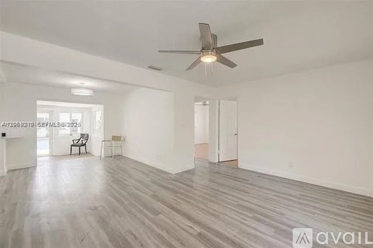 A spacious room with a ceiling fan and lighting fixtures.