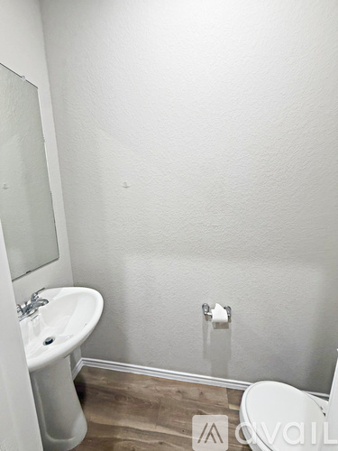A white sink and toilet in a small bathroom.