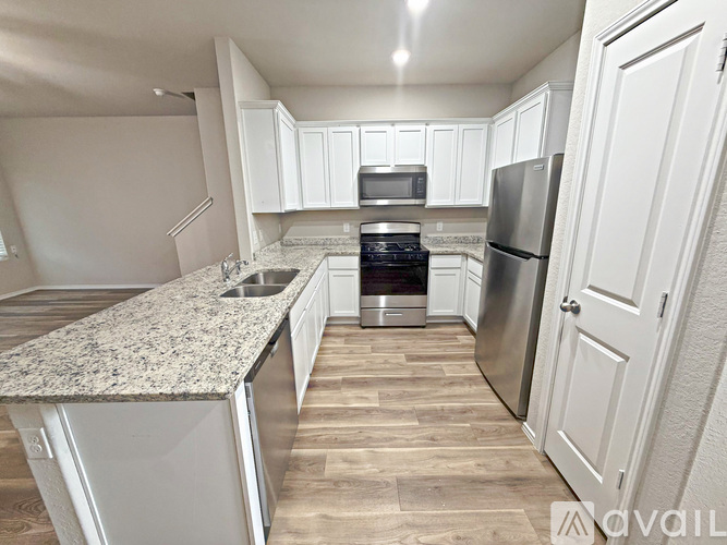 A kitchen with a granite countertop and stainless steel appliances.