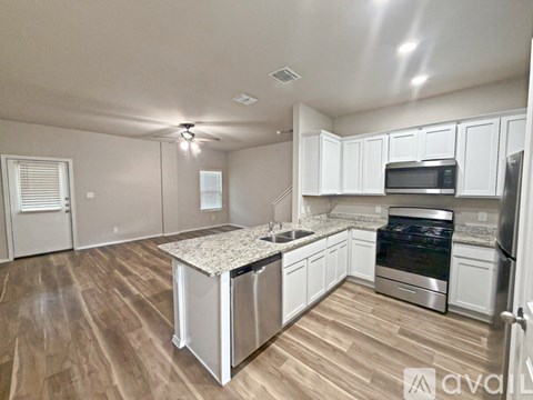 A kitchen with white cabinets and stainless steel appliances.