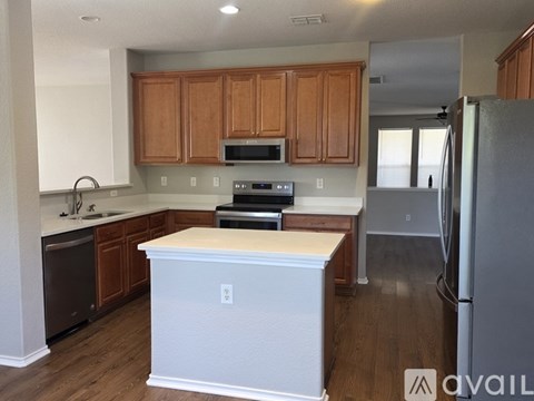 A kitchen with wooden cabinets and a white island.