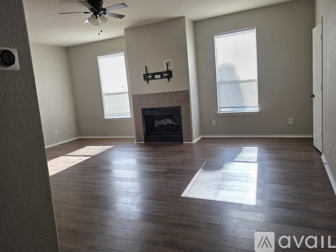 A living room with a fireplace and a ceiling fan.