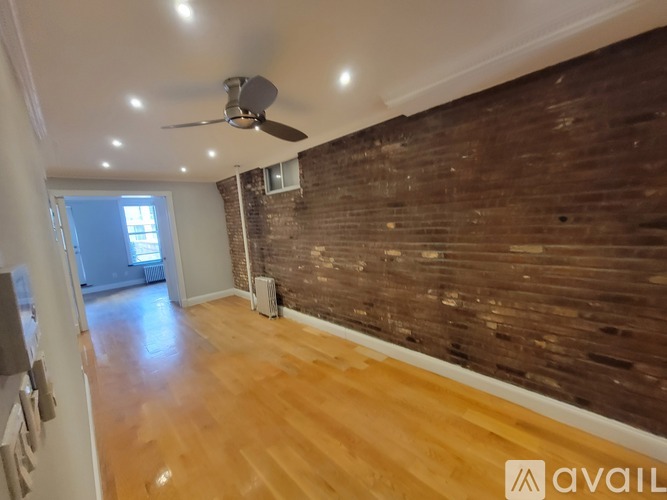 A room with wooden floors and a brick wall.