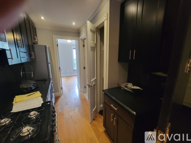 A kitchen with black cabinets and a stove top oven.