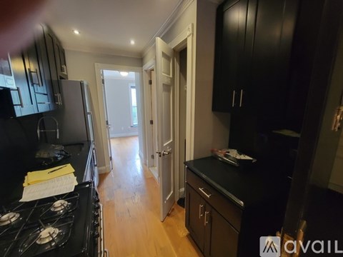 A kitchen with black cabinets and a stove top oven.