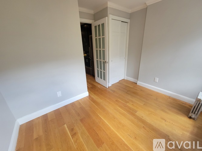 A room with wooden flooring and a white door.