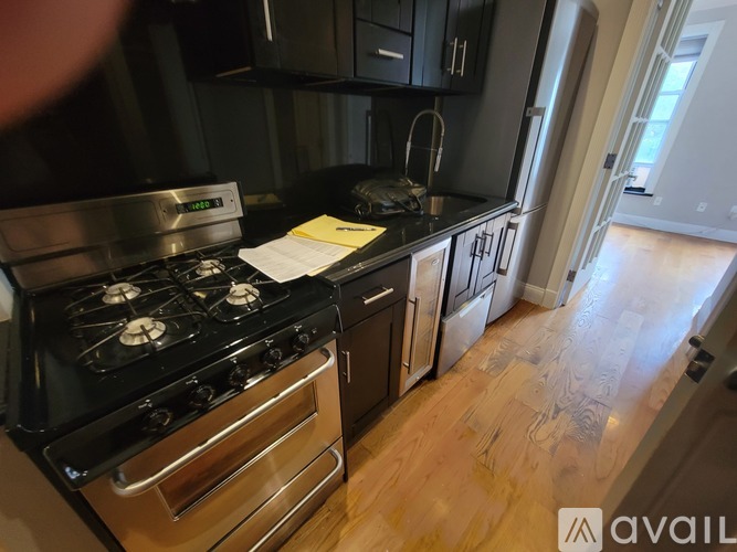 A modern kitchen with a stove, oven, and wooden floors.