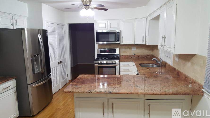 A kitchen with a granite countertop and stainless steel appliances.