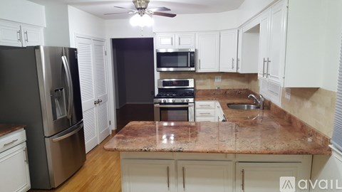 A kitchen with a granite countertop and stainless steel appliances.
