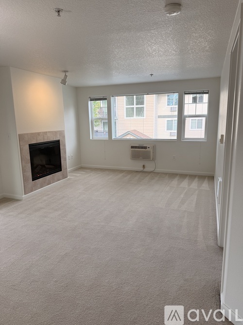 A living room with a fireplace and carpeted floor.