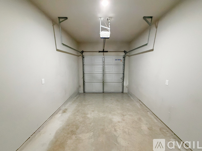 A spacious garage with a white door and a concrete floor.