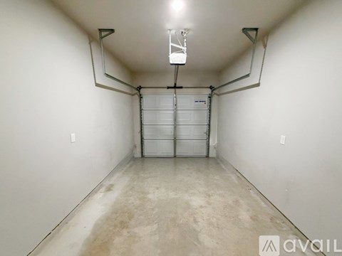 A spacious garage with a white door and a concrete floor.