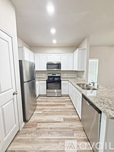 A kitchen with white cabinets and a granite countertop.