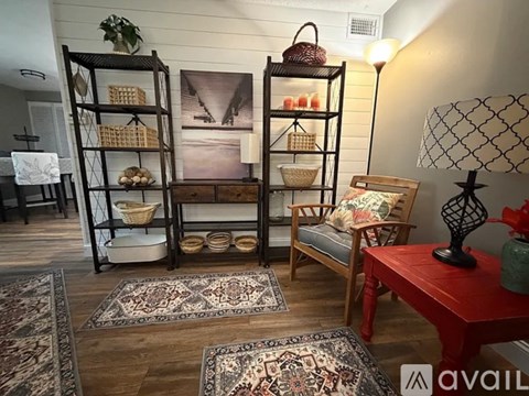 A living room with a red table and a wooden chair.