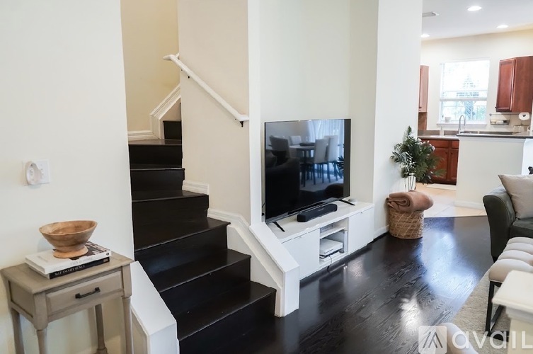 A living room with a black staircase and a television.