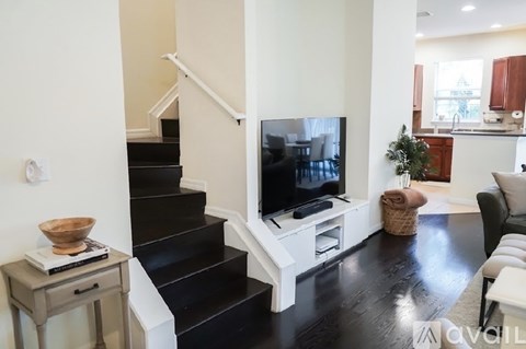A living room with a black staircase and a television.