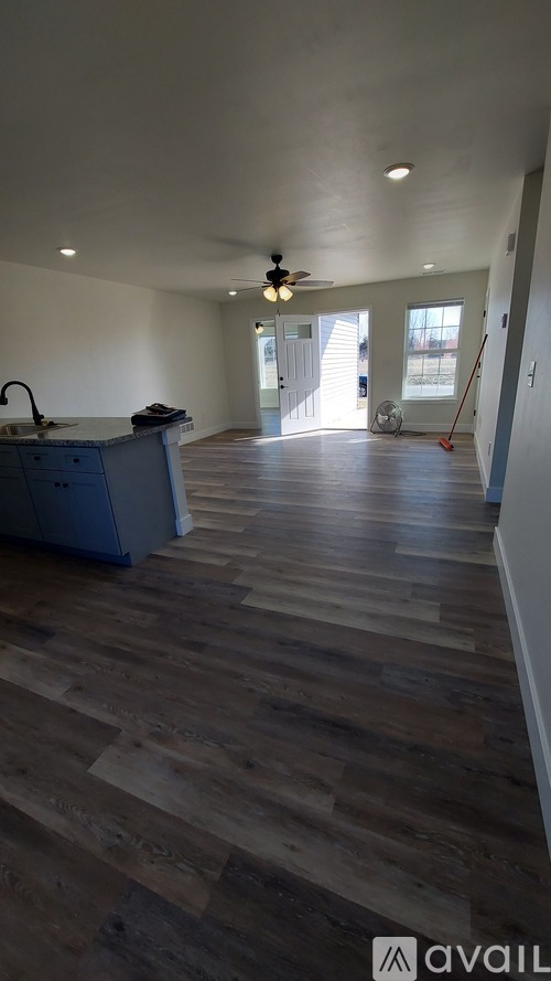 A room with wooden flooring and a ceiling fan.