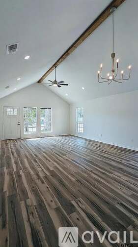 A room with wooden flooring and a chandelier.