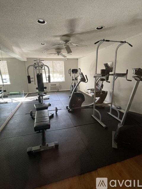 A gym with a variety of equipment including a weight bench, a leg press machine, and a rowing machine.