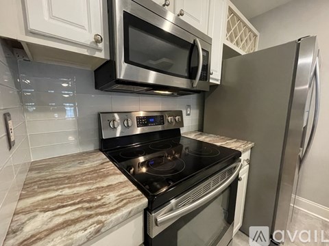 A modern kitchen with a stainless steel refrigerator and a black oven.