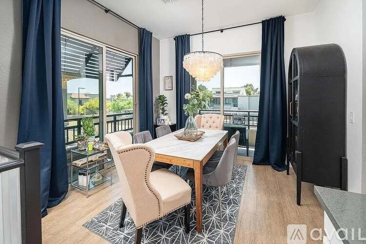 A dining room with a table set for four and a view of the backyard.
