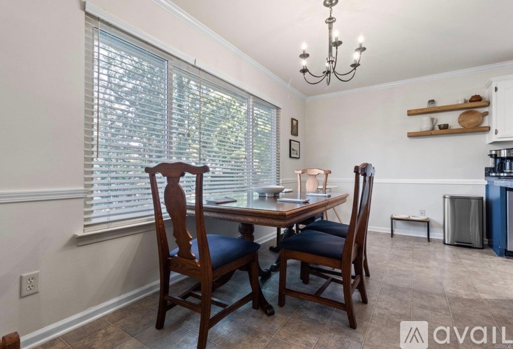 A dining room with a table and chairs.