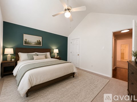 A bedroom with a large bed and a ceiling fan.