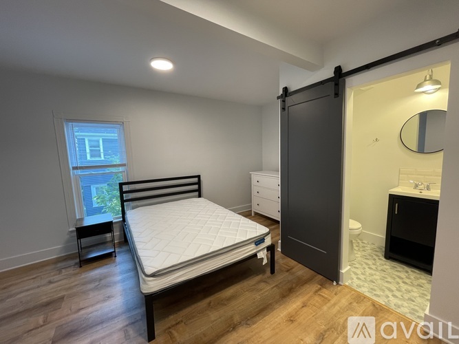 A bedroom with a bed, dresser, and mirror.
