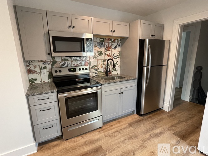 A kitchen with a stove top oven, microwave, and refrigerator.