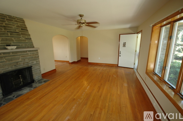 A living room with a fireplace and wood flooring.