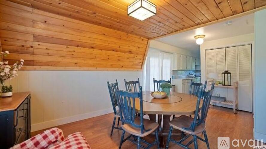 A wooden dining room with a table set for four.