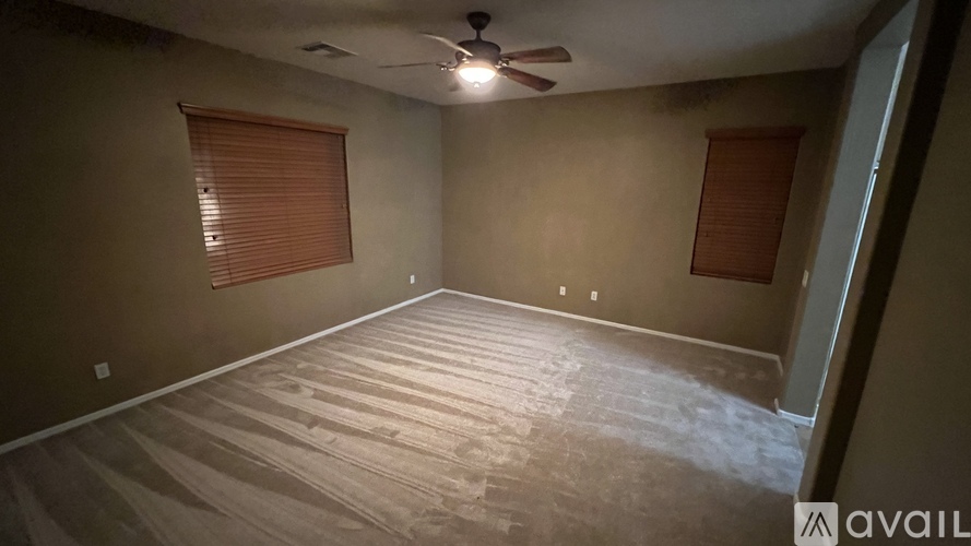 A room with a ceiling fan and wooden flooring.