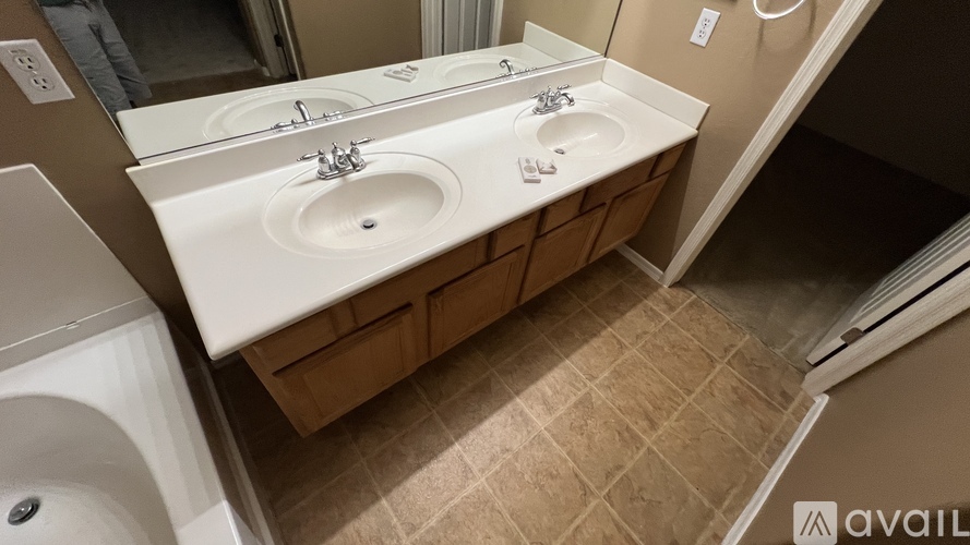 A bathroom with two sinks and a washer and dryer.