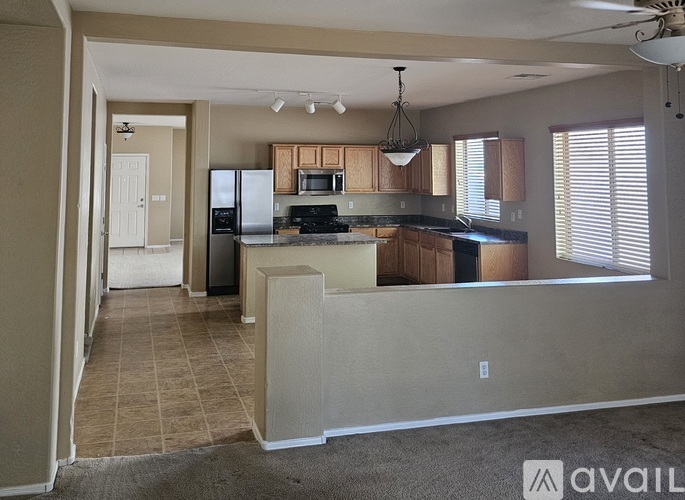A kitchen with a refrigerator, microwave, and oven.