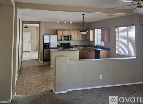A kitchen with a refrigerator, microwave, and oven.