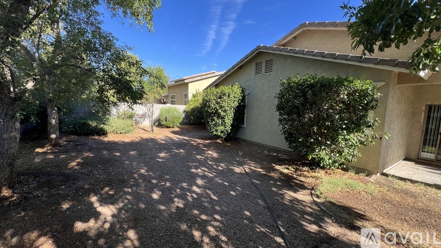 A house with a driveway and trees in front of it.