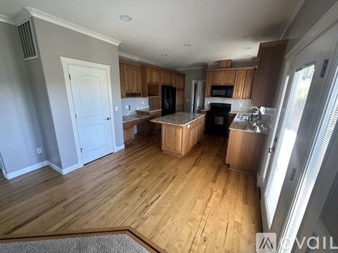 A kitchen with wooden floors and a white door.