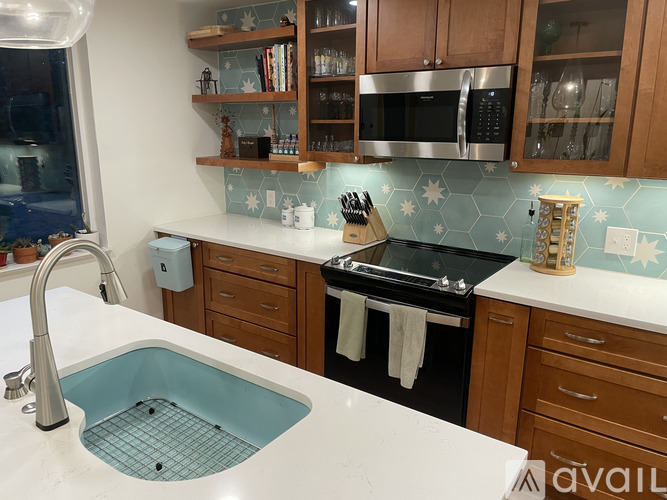 A kitchen with a sink, stove, and microwave.