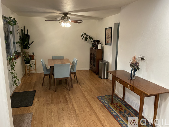 A dining room with a wooden table and chairs.