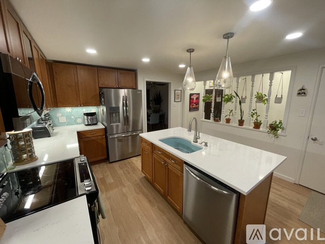 A modern kitchen with wooden cabinets and stainless steel appliances.