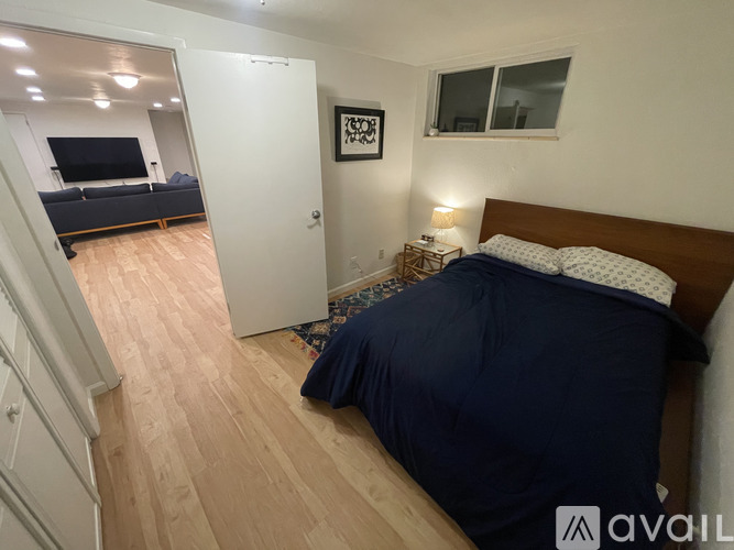 A bedroom with a bed, a couch, and a painting on the wall.
